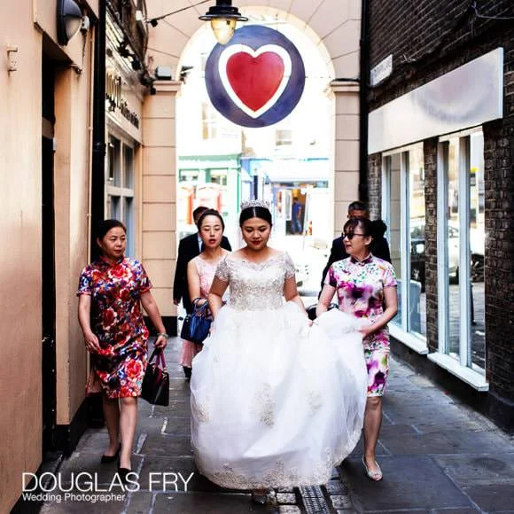 Wedding Photographer The Admirals House, Old Royal Naval College in Greenwich 2 Bride walking through Greenwich Market beneath sign of heart