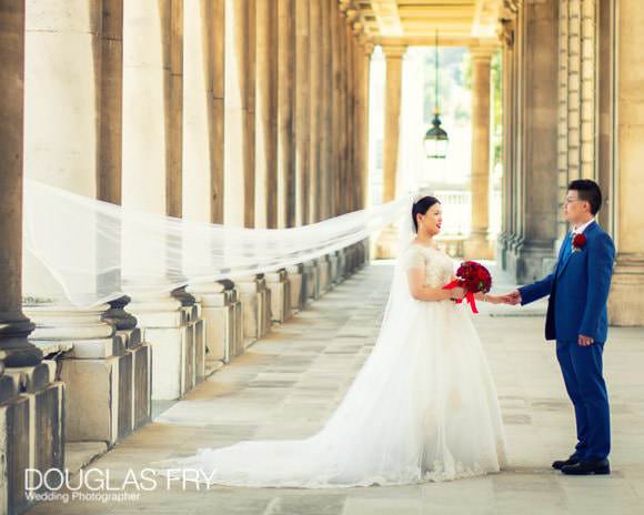 Bride with groom photographed amongst the colonades at Admirals House