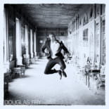 Groom pictured in black and white in Syon House after wedding ceremony - leaping in the air