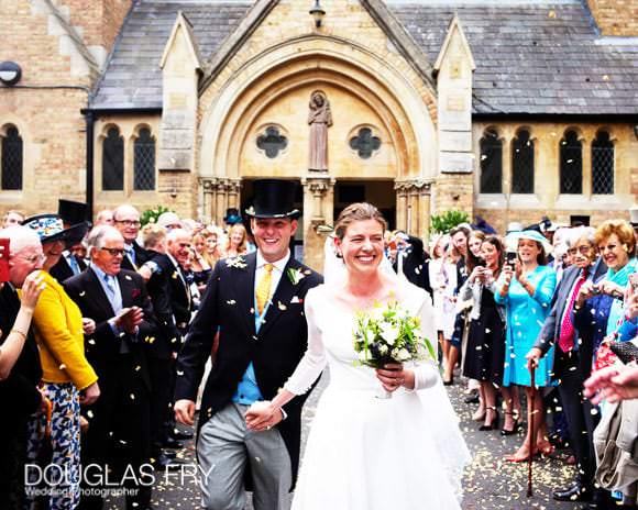 Bride and groom leaving church with confetti on wedding day