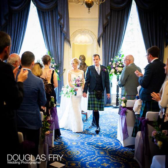 The bride and groom walking down the aisle at the Caledonian Club at the end of the wedding ceremony