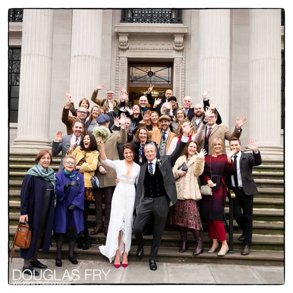 Wedding Photographer Marylebone Town Hall and the Ivy 5 couple with wedding guests on Marylebone Town Hall steps - wedding photograph of group