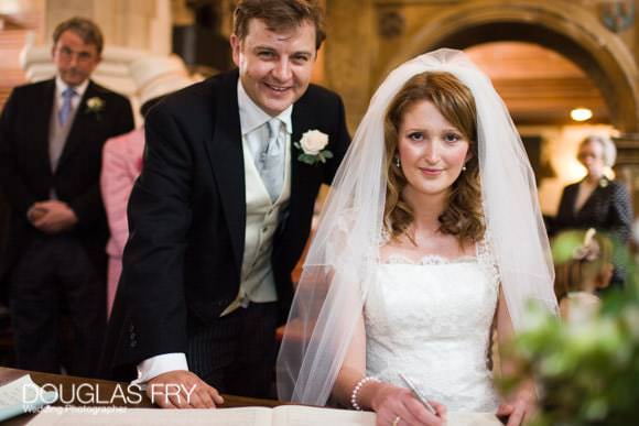 Bride and groom signing register in Chelsea Old Church