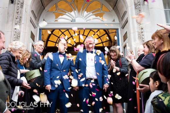 Wedding party photographed on the steps of Chelsesa Town Hall with confetti by Chelsea wedding photographer