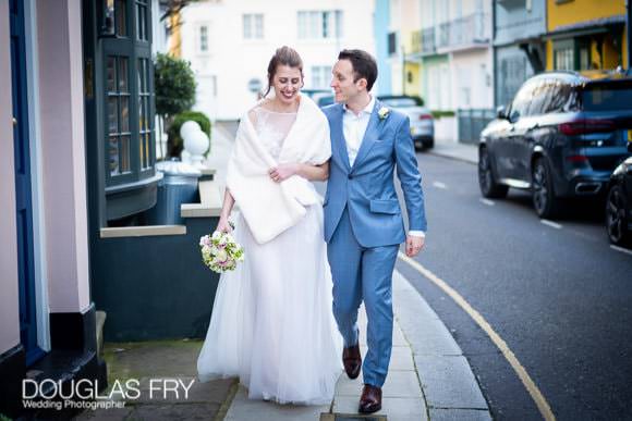 Couple phootgraphed on wedding day walking along Chelsea street