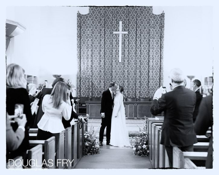 Wedding couple pose for the camera while the guests settle for the wedding breakfast