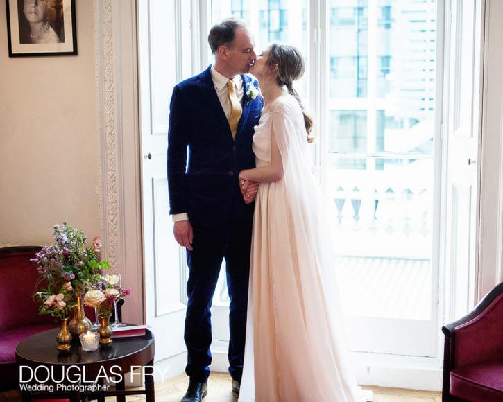 Wedding couple pose for the camera while the guests settle for the wedding breakfast