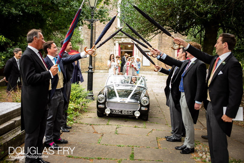London wedding photographer leaving by car through umbrellas arch