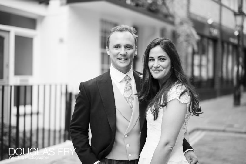 couple photographed together in front of Londo restuarant by Douglas Fry Wedding Photographer London