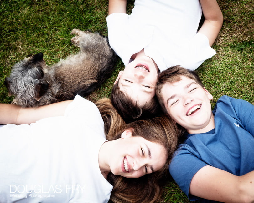 Teenage children and dog photographed at home in Wiltshire on the lawn