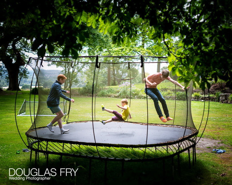 Family photography of children on trampoline at home in Berkshire