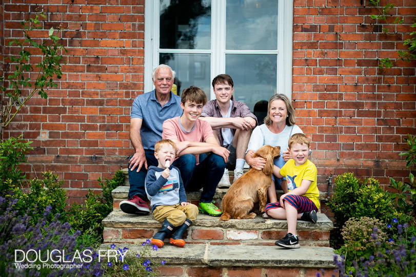 Family photograph - group shot of everyone together with the dogs in front of the house