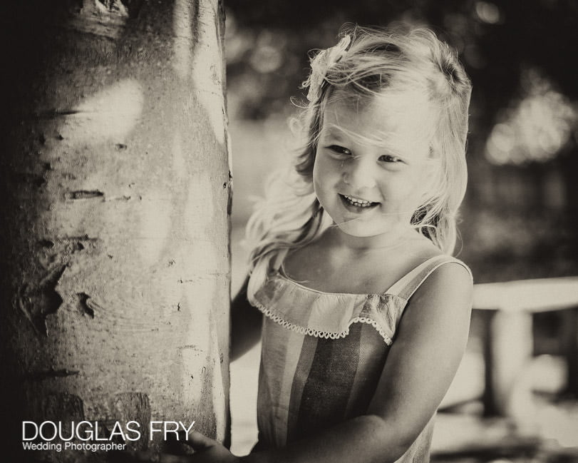 Daughter looking around tree in the garden