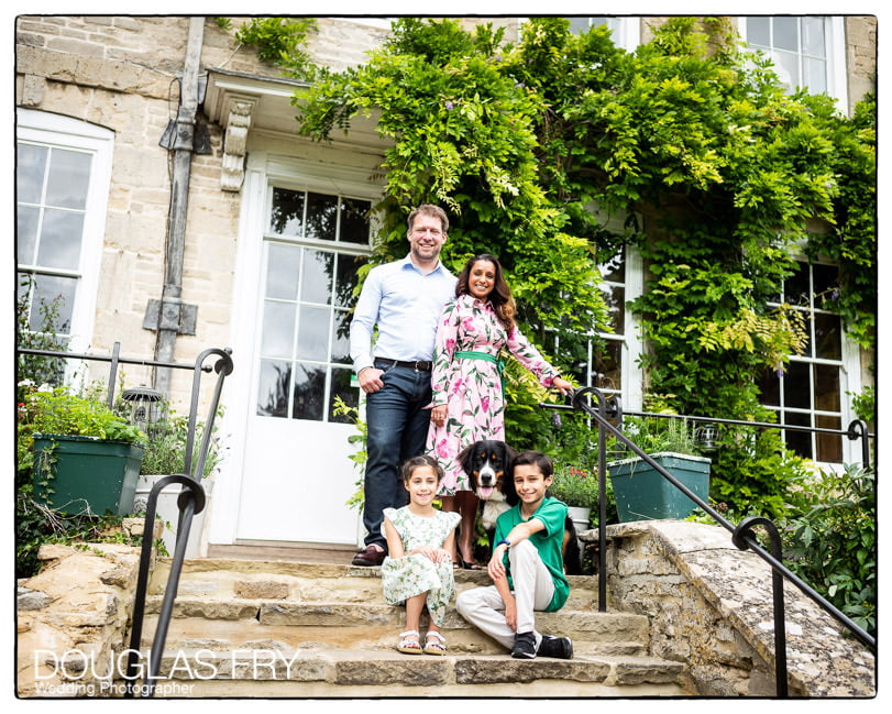 Family photographed in front of family home with dog