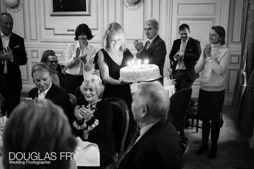 90th Birthday Party Photographer at the In and Out Club in London 13 Birthday Party Photographer London - The cake being brought in