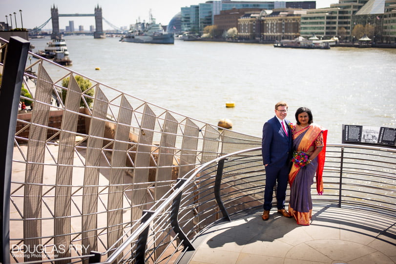 Bride and groom photographed together with Tower Bridge behind