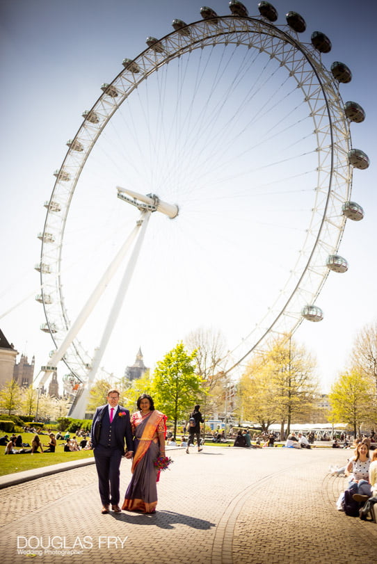 Bride and groom photographed together in front of the London Eye