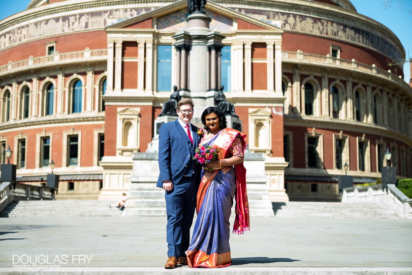 Bride and groom photographed together on the steps of the Albert Hall in London