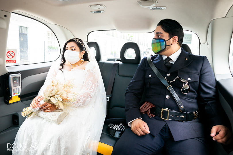 couple photographed together on way to wedding in taxi