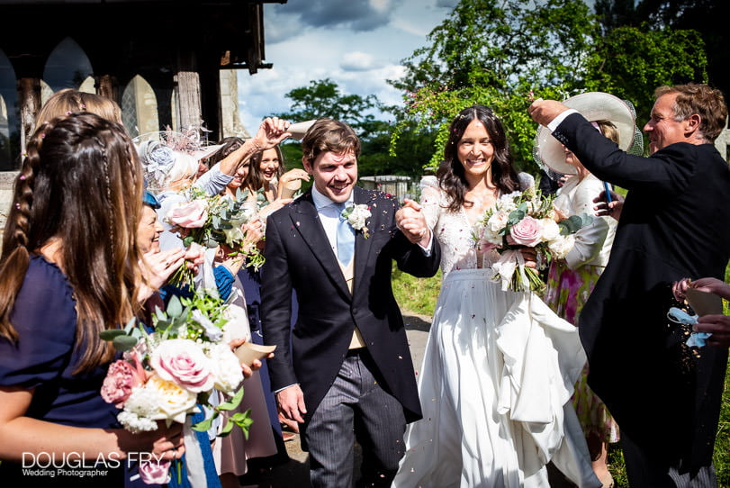 Couple leaving church photographed with confetti