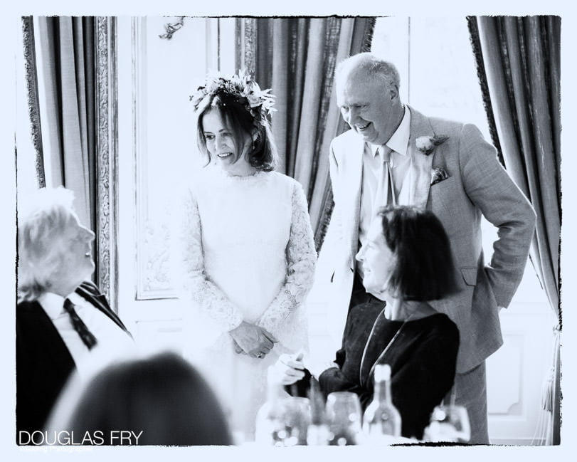 Couple photographed speaking to guests during wedding reception in Savile Club London