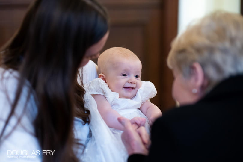 Baptism photographer at Farm Street Church - Smiling baby photogarph