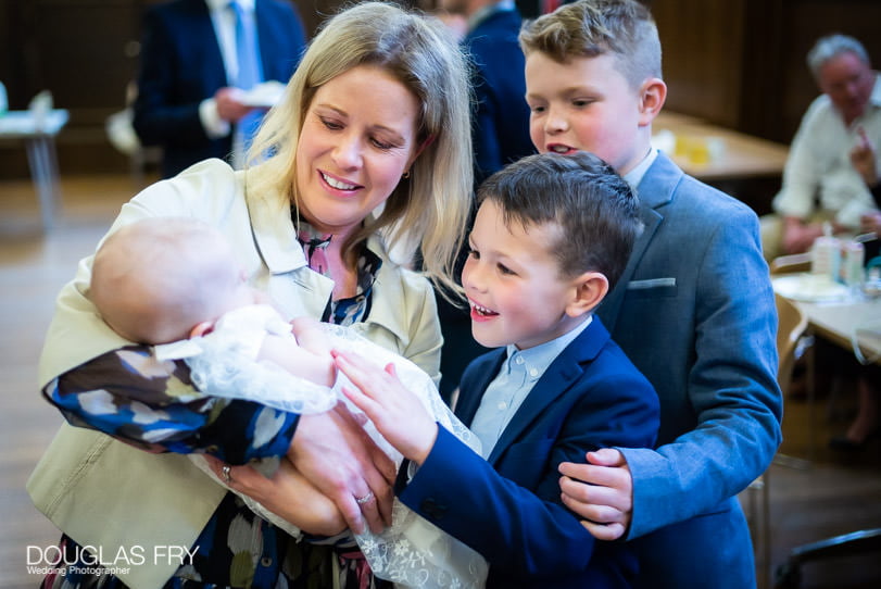 Baptism photographer at Farm Street Church in London - family with baby