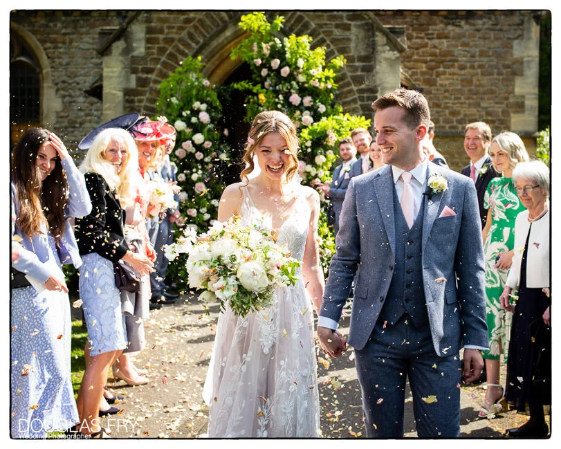 Wedding Photographed at RAC Woodcote Park 1 Couple leaving church with confetti