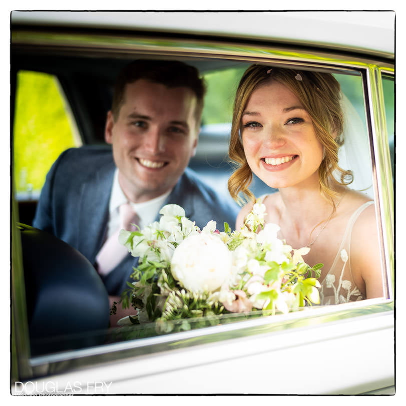 couple in car on way to wedding reception