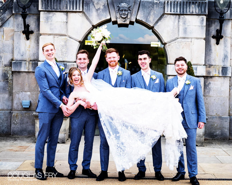 formal photograph with bride held aloft at RAC Woodcote Park