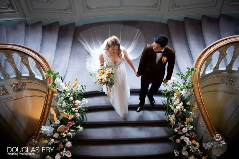 Couple photographed during wedding on stairs at the Savile Club in London