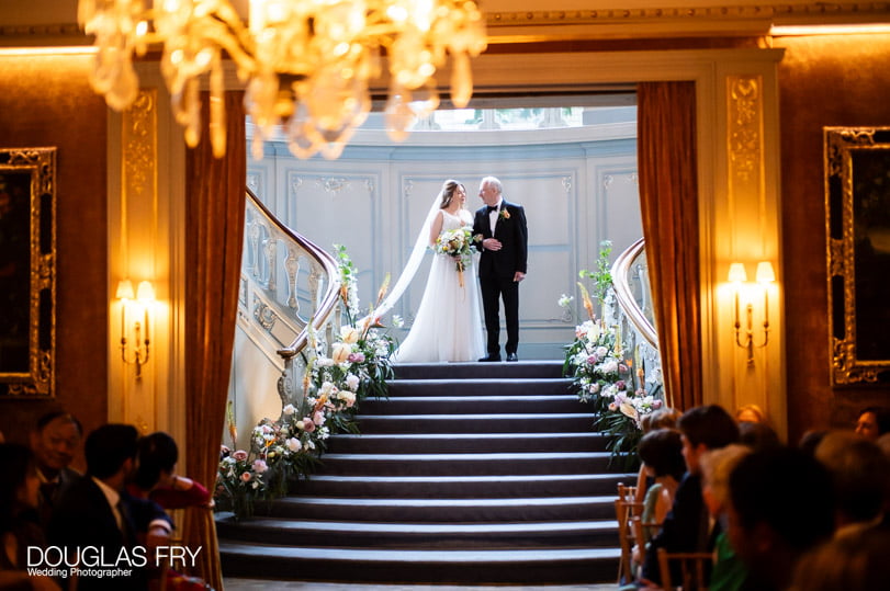 Bride with her father on stairs at the Savile Club