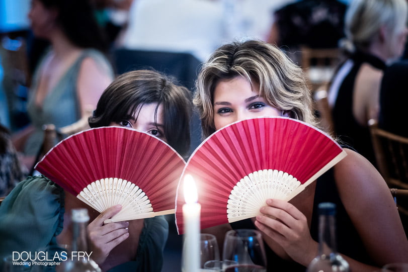 Guests with fans at Savile Club wedding