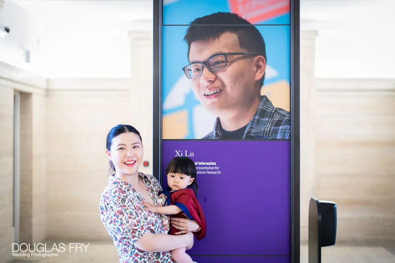 Graduation Day Family Photography on London's Southbank 1 Kings College poster featuring Xi - family photographed in front of the billboard.