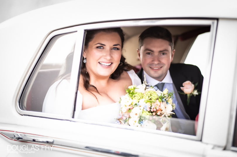 Wedding photographer - couple in car at in Dulwich church