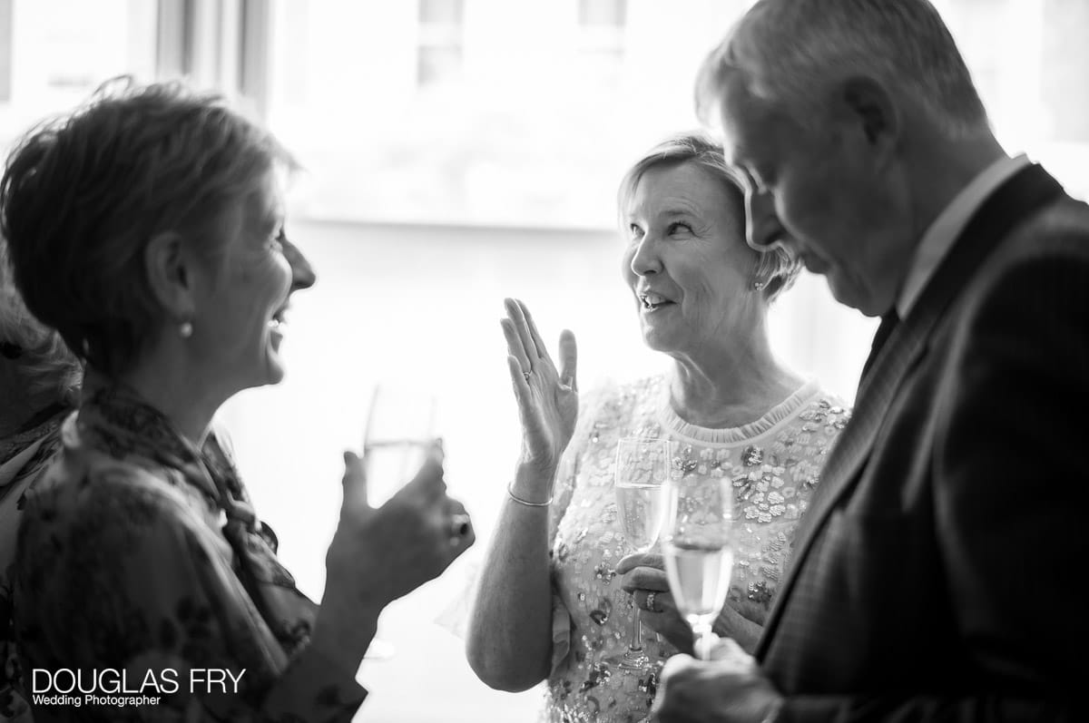 Wedding photography by Douglas Fry of couple cutting cake at home during reception.