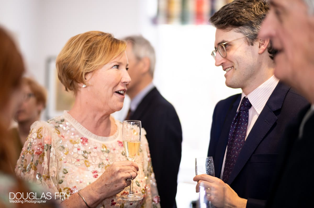 Wedding photography by Douglas Fry of couple cutting cake at home during reception.