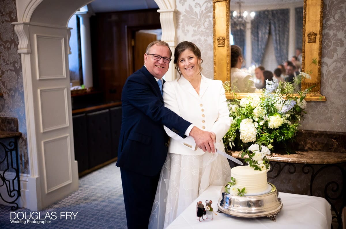 Wedding photograph of couple cutting the cake at the Petersham Hotel