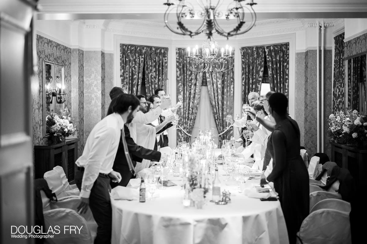 Wedding photograph of guests toasting the happy couple at the Petersham Hotel