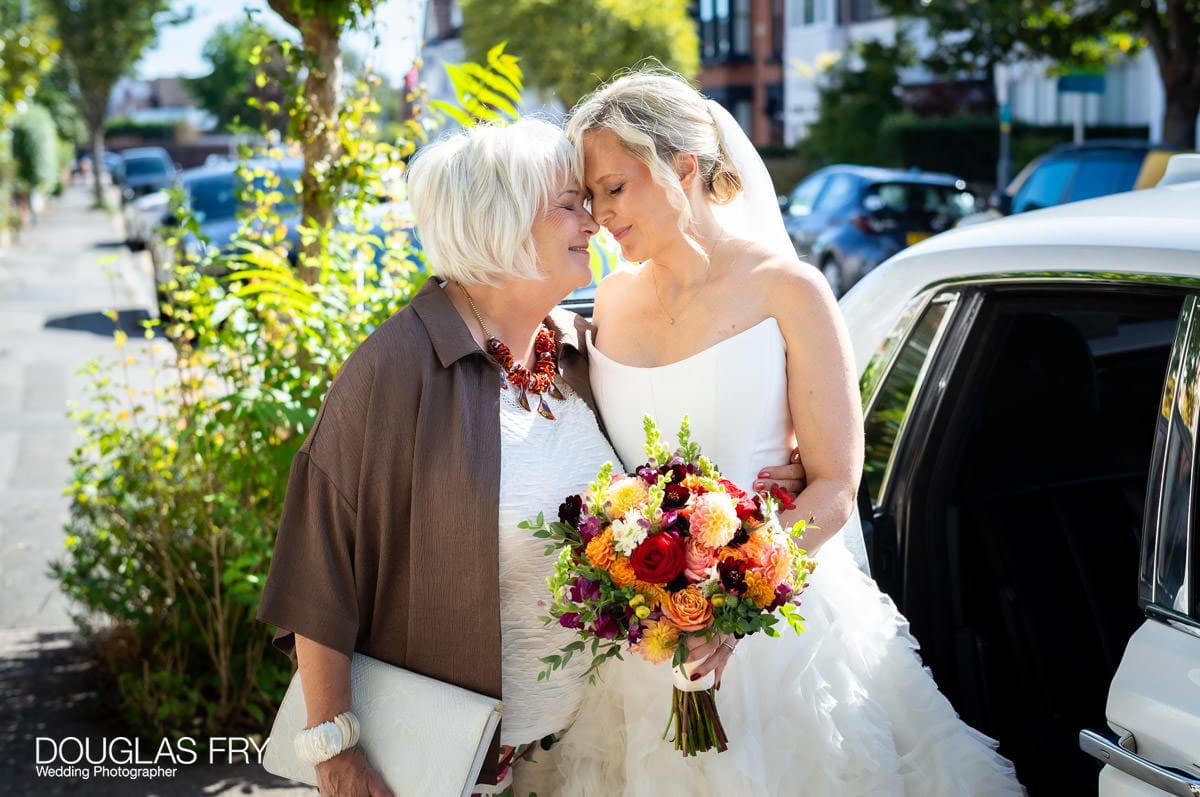 Wedding photography of bride and mother leaving by car in London
