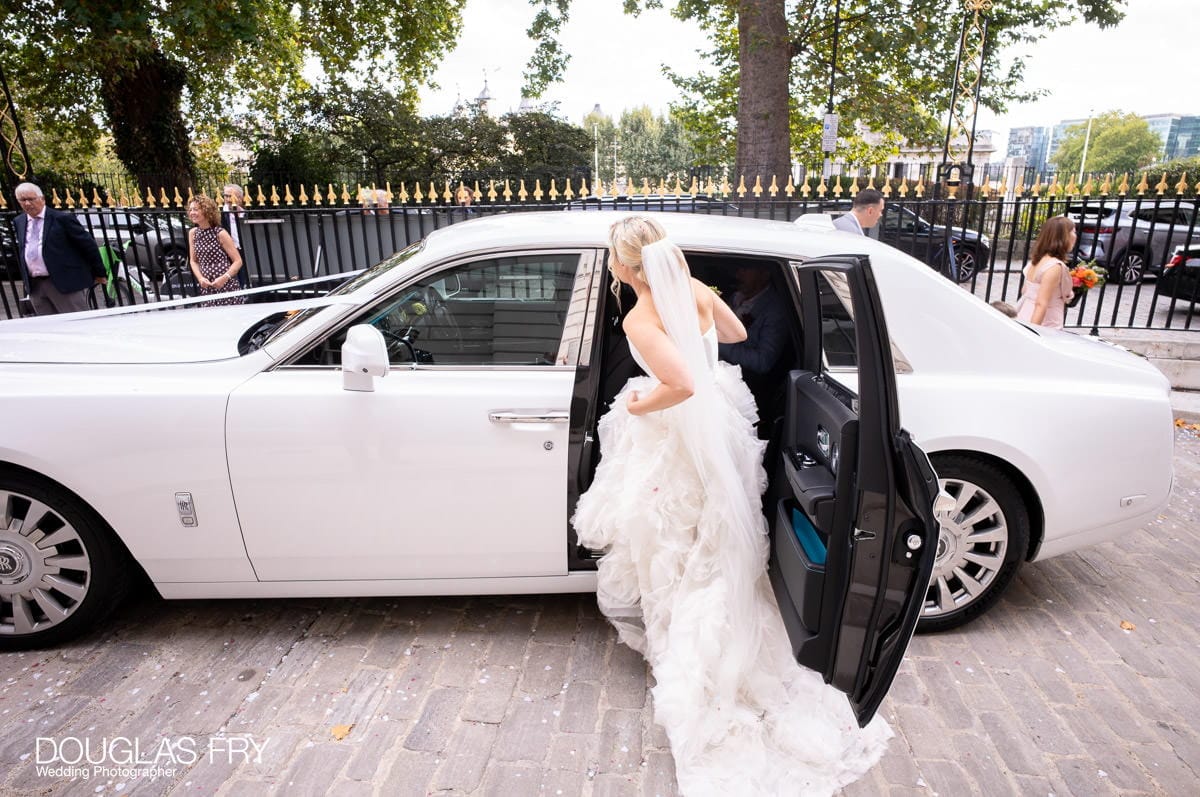 Bride getting into car to leave wedding - photographed by wedding photographer in London